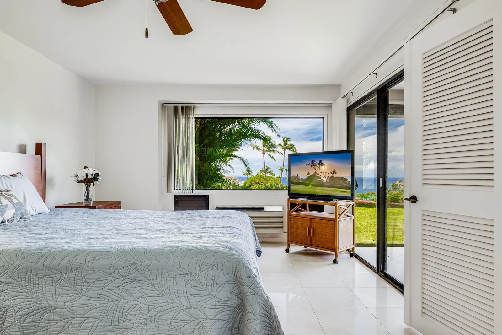 A bright Wailea bedroom opening to a framed view of palms and the ocean